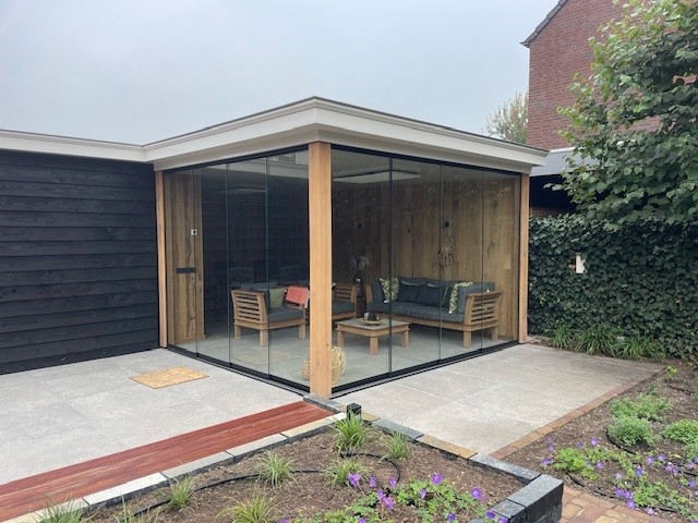 Black aluminum bifold glass doors fully opened connecting indoor living space to outdoor patio area