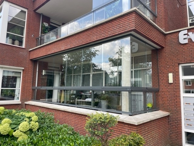 Black aluminum bifold glass doors fully opened connecting indoor living space to outdoor patio area