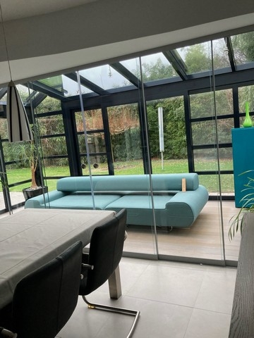 Black aluminum bifold glass doors fully opened connecting indoor living space to outdoor patio area