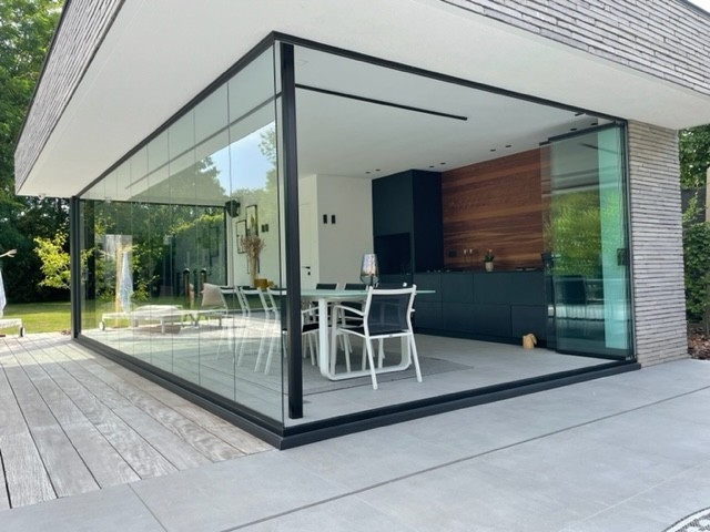 Black aluminum bifold glass doors fully opened connecting indoor living space to outdoor patio area