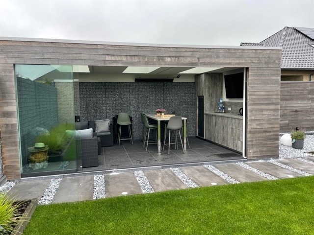 Black aluminum bifold glass doors fully opened connecting indoor living space to outdoor patio area