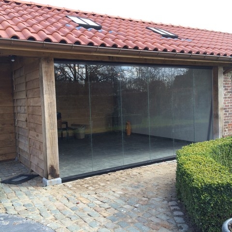Black aluminum bifold glass doors fully opened connecting indoor living space to outdoor patio area