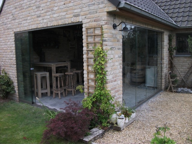 Black aluminum bifold glass doors fully opened connecting indoor living space to outdoor patio area