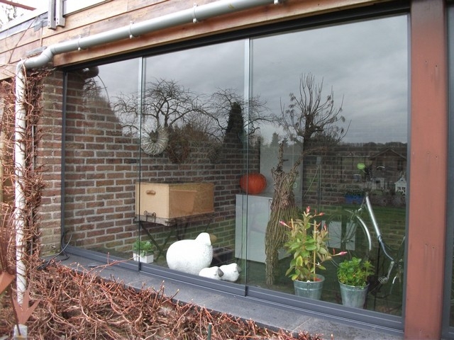 Black aluminum bifold glass doors fully opened connecting indoor living space to outdoor patio area
