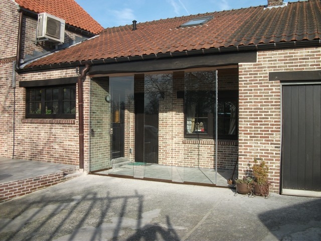 Black aluminum bifold glass doors fully opened connecting indoor living space to outdoor patio area