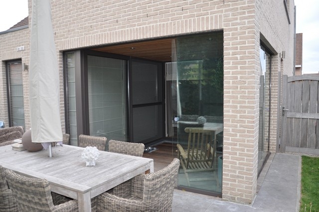 Black aluminum bifold glass doors fully opened connecting indoor living space to outdoor patio area