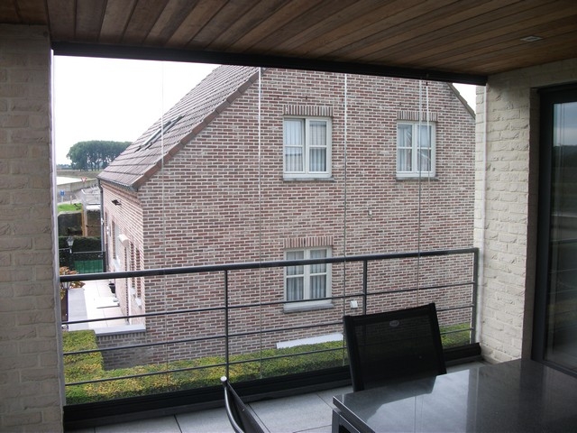 Black aluminum bifold glass doors fully opened connecting indoor living space to outdoor patio area