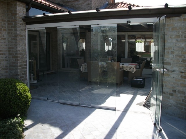 Black aluminum bifold glass doors fully opened connecting indoor living space to outdoor patio area